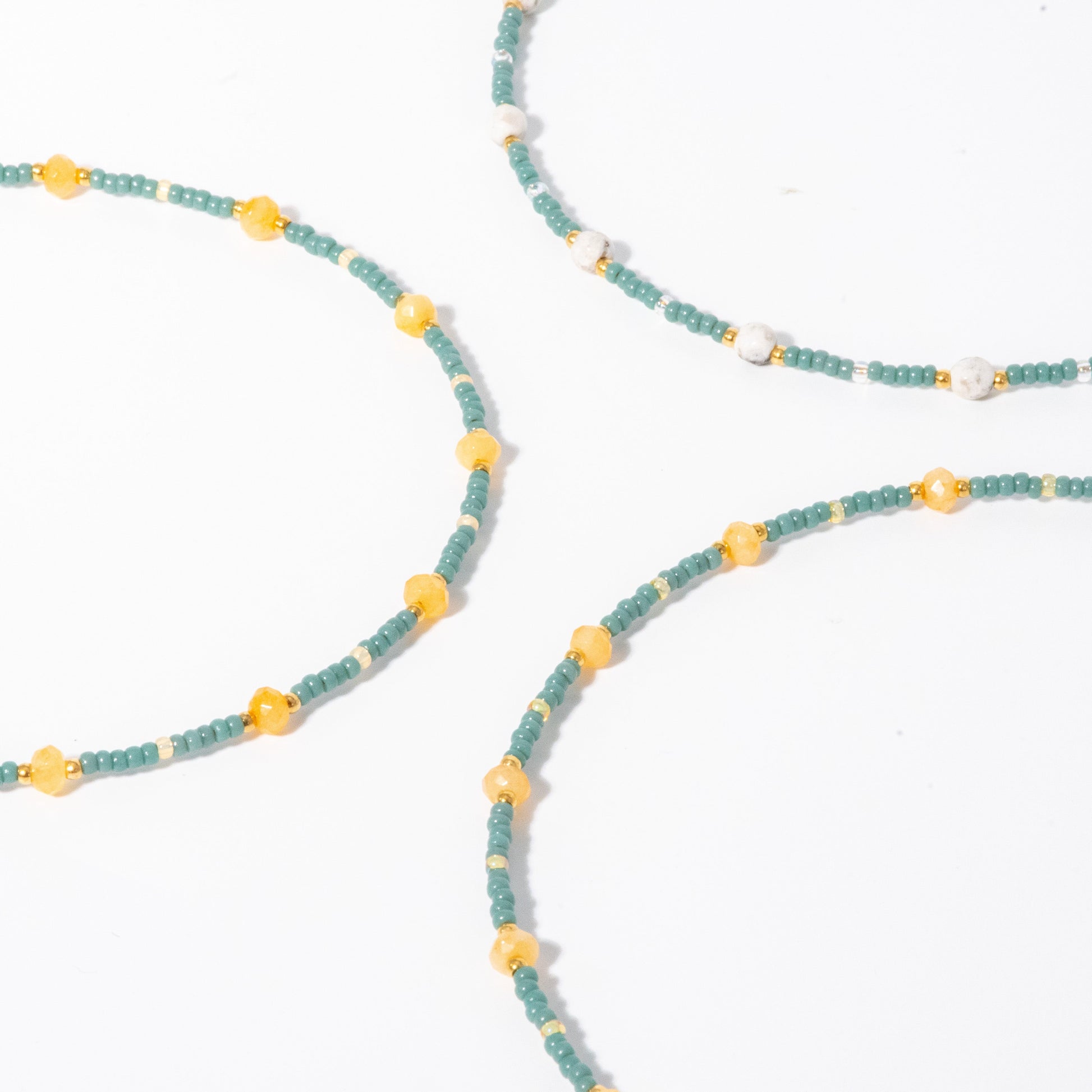 Close-up of a beaded necklace with blue and yellow beads on a white background