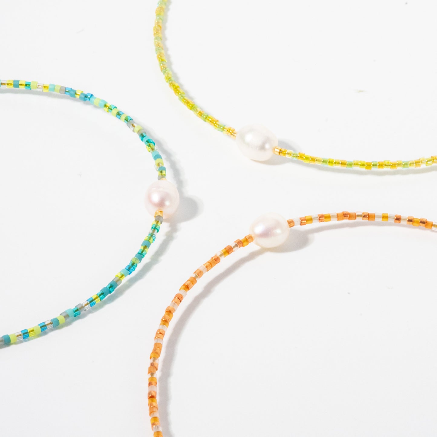 Three colorful beaded necklaces on a white background